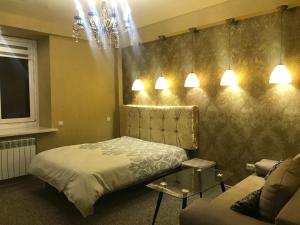 a bedroom with a bed and a couch and lights at Apartment near Dnipro Arena in Dnipro