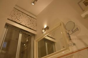 een badkamer met een spiegel en een raam bij dormiRÈtrani in Trani