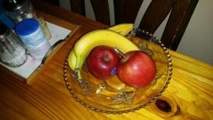 un bol de frutas con manzanas y plátanos en una mesa en B & B Kostelijk en Boekelo