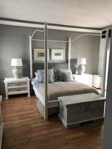 een slaapkamer met een hemelbed en 2 nachtkastjes bij Banus Lovely Apartment in Marbella
