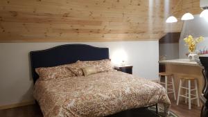 a bedroom with a bed with a wooden ceiling at The White Birch Inn in Berwick