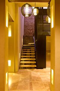 a hallway with a staircase with chandeliers at Bastión Luxury Hotel in Cartagena de Indias