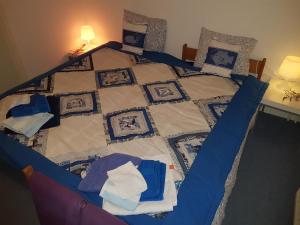 - un lit avec une couette bleue et blanche dans l'établissement de Twee Paardjes, à Warffum