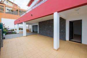 an empty courtyard of a building with a red roof at Duplex Palmarejo Baixo in Praia