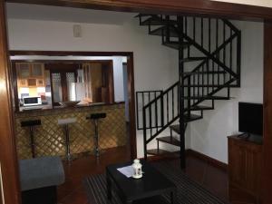 ein Wohnzimmer mit einer Wendeltreppe und einem Tisch in der Unterkunft DDS-Dominio das Sem&ntes in Vouzela