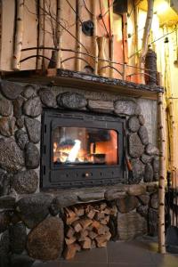 a stone fireplace with a fire in it at Casa Anina in Anina