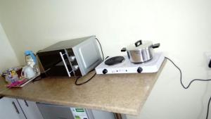 a counter top with a microwave and a computer monitor at Hillside View Guesthouse in Coffee Bay
