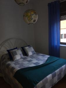 ein Schlafzimmer mit einem Bett mit blauen Vorhängen und einem Fenster in der Unterkunft DDS-Dominio das Sem&ntes in Vouzela