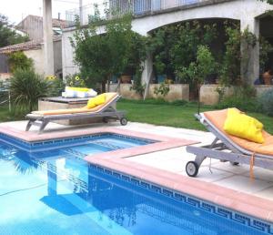 a swimming pool with two lounge chairs next to it at La Forge in Gignac