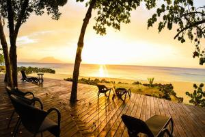 una terraza de madera con sillas y vistas al océano en Luxury Oceanview Condo 2 BR/2.5 BA, en Sosúa