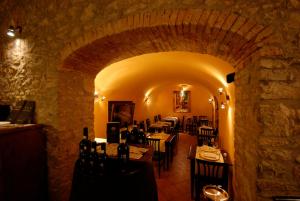 comedor con mesas y sillas en una pared de piedra en Locanda All'Andreas, en Montemerano