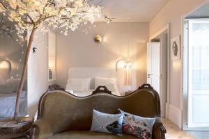 ein Schlafzimmer mit einem Bett und einem Sofa und einem Baum in der Unterkunft BOUTIQUE Rentals - Little Treasure Studio in Porto