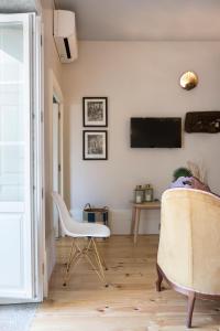 ein Wohnzimmer mit einem TV und 2 Stühlen in der Unterkunft BOUTIQUE Rentals - Little Treasure Studio in Porto