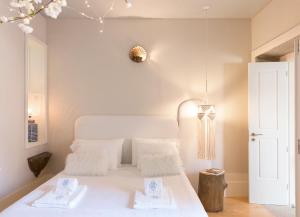 ein Schlafzimmer mit einem weißen Bett mit weißen Kissen in der Unterkunft BOUTIQUE Rentals - Little Treasure Studio in Porto
