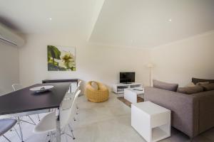 a living room with a couch and a table at Escape At Nobbys Executive Townhouse 1 74 Pacific Drive in Port Macquarie