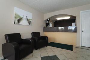 a waiting room with two chairs and a mirror at Executive Inn - Panama City Beach in Panama City Beach