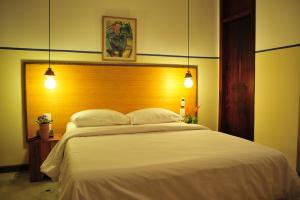 a bedroom with a large white bed with two pillows at Pousada da Sesmaria in São Sebastião