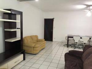 a living room with a couch and a table at Cobertura vista para o mar in Praia Grande