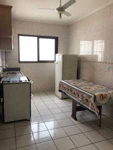 a kitchen with a stove and a refrigerator at Cobertura vista para o mar in Praia Grande