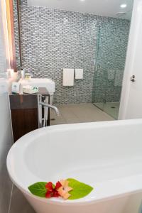 a bathroom with a tub with a sink and a shower at The Palms Denarau Fiji in Denarau