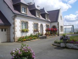 a house with flowers in front of it at Maison Avec Piscine in Plérin