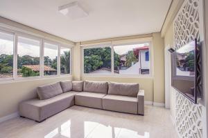 uma sala de estar com um sofá e uma televisão de ecrã plano em Pousada Native em Florianópolis