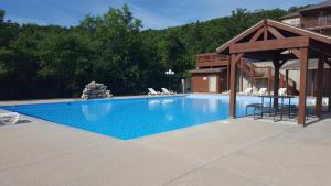 a swimming pool with a gazebo next to a house at Rockwood Condos on Table Rock Lake With Boat Slips in Branson