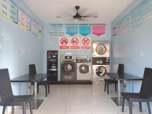 a laundry room with two tables and a washing machine at Venus Boutique Hotel in Malacca
