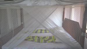 a small bed with a canopy and a striped pillow at Leisure Home Mirissa in Mirissa