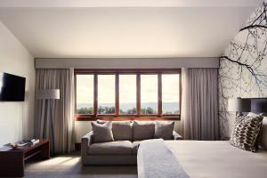 a bedroom with a bed and a couch and a window at Spicers Peak Lodge in Maryvale