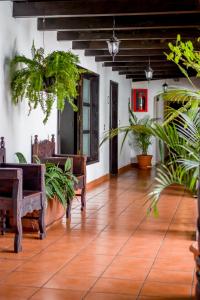 a living room with wooden floors and plants at Hotel Villa Real Antigua in Antigua Guatemala