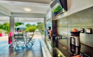 cocina con fogones y mesa con sillas en JoliReveCreole, en Sainte-Anne