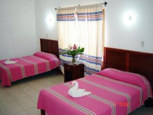 Una cama o camas en una habitación de Hotel De Santiago