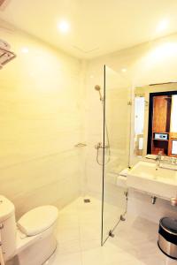 e bagno con servizi igienici, lavandino e doccia. di Kautaman Hotel a Mataram
