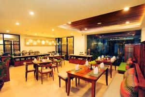 a restaurant with tables and chairs in a room at Kautaman Hotel in Mataram