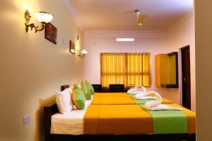 duas camas num quarto de hotel com cisnes em Hisham Residency em Kakkanad