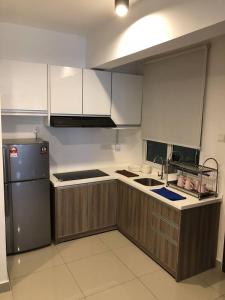 a kitchen with wooden cabinets and a stainless steel refrigerator at Dream of the summer Ipoh in Ipoh