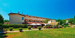 un grand bâtiment avec une pelouse devant lui dans l'établissement Albergo Della Roccia, à Varano deʼ Melegari