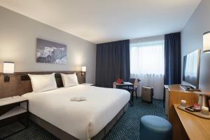 a hotel room with a large bed and a television at Mercure Paris Roissy CDG in Roissy-en-France