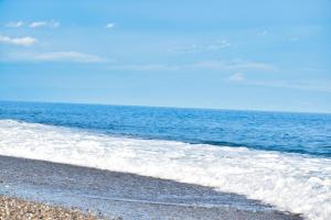 einen Strand mit Meer an einem sonnigen Tag in der Unterkunft Valentina Holiday House in Mascali