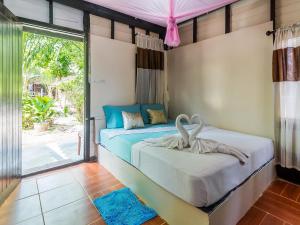 a bedroom with a bed and a large window at Leaf House Bungalows in Ko Lanta