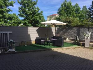 eine Terrasse mit einem Tisch und einem Sonnenschirm in der Unterkunft Nuovo Hotel Vigevano in Vigevano