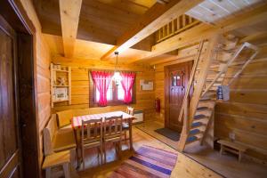 a dining room with a table and stairs in a log cabin at Drevenice TriMount in Liptovský Mikuláš