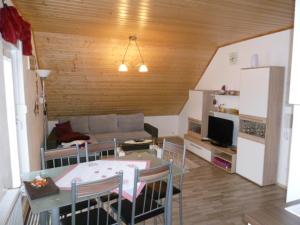 ein Wohnzimmer mit einem Sofa und einem Tisch mit Stühlen in der Unterkunft BodenSEE Apartment Meckenbeuren Hasenwinkel in Meckenbeuren