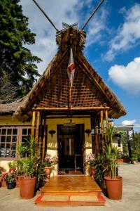 a small house with a thatched roof at Niraamaya Retreats Aradura Kohima in Kohīma
