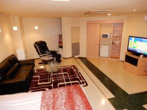 a living room with a couch and a flat screen tv at Hotel Shindbad Aomori -Love Hotel- in Aomori