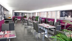 un restaurant avec des tables, des chaises et des murs violets dans l'établissement Privilège Hôtel & Apparts Eurociel Centre Comédie, à Montpellier