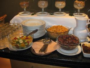 ein Buffet mit Schalen und Teller mit Speisen auf dem Tisch in der Unterkunft City Hotel in Linz