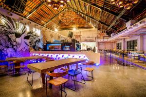 a restaurant with tables and chairs in a room at Solia Legian Bali in Legian