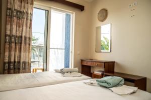 two beds in a room with a window at Sevastos Studios in Faliraki